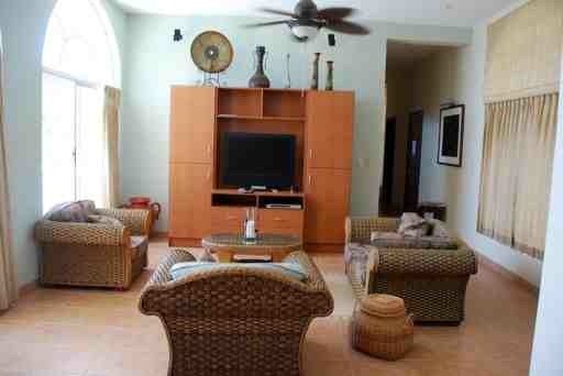 Fully furnished living room with flat-screen TV.