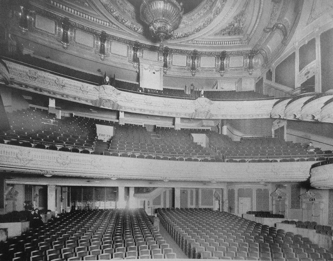 Historic Palace Theatre auditorium with tightly arranged rows of fixed theater seating
