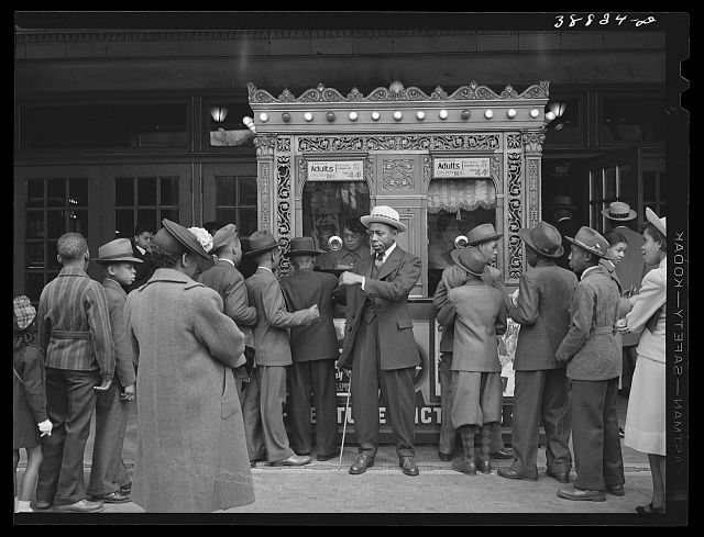 Entrance to a Chicago movie theater in 1941 with promotional signs and poster displays