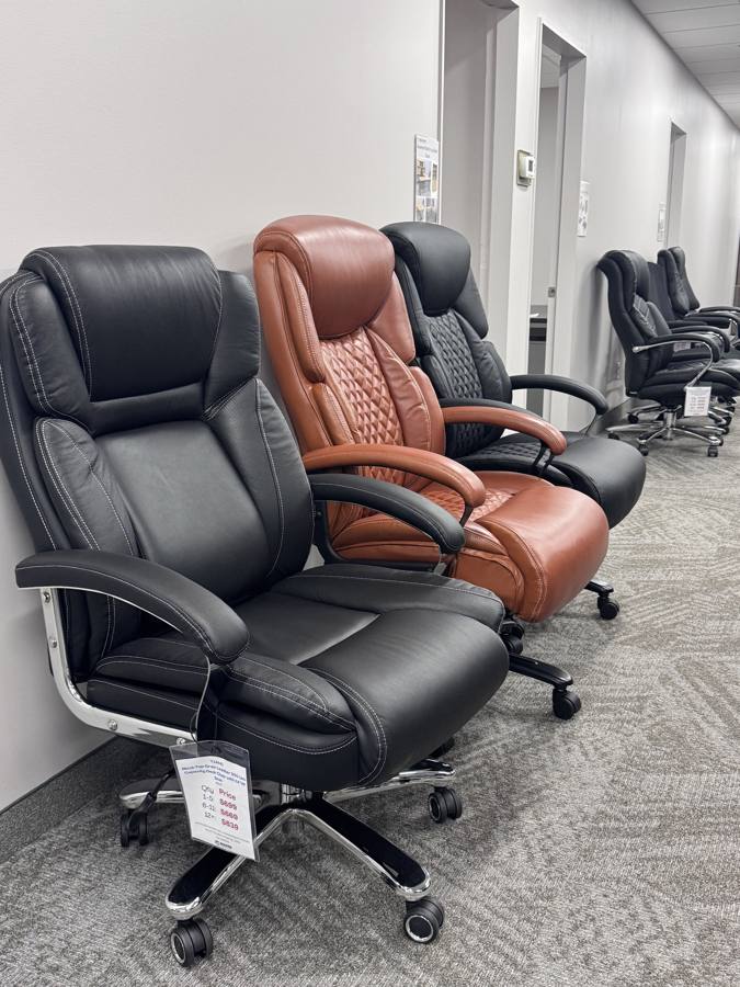 Row of big and tall leather office chairs on display in the showroom
