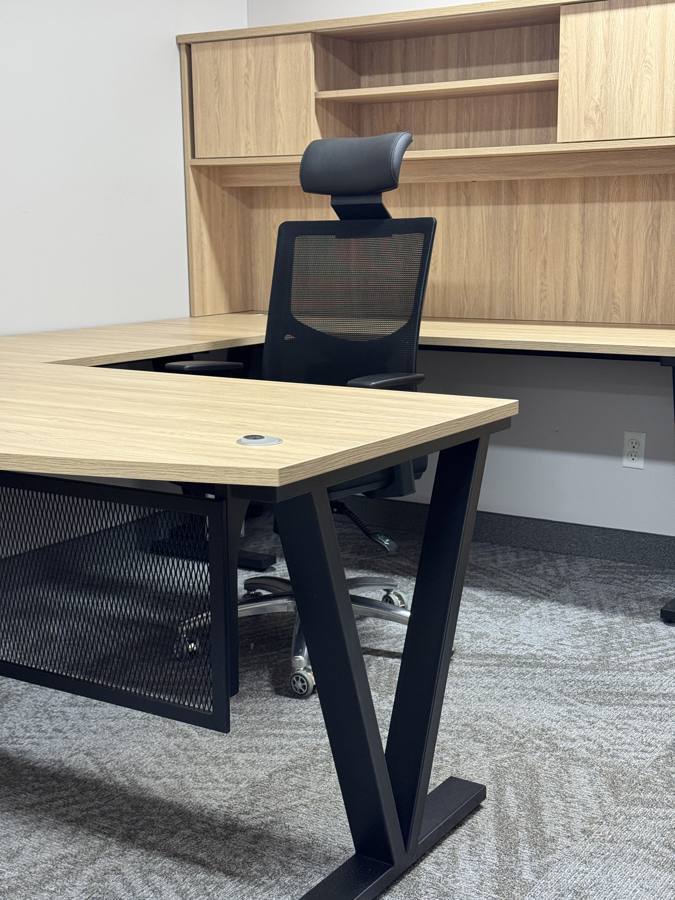 L-shaped desk with hutch and mesh chair in the showroom