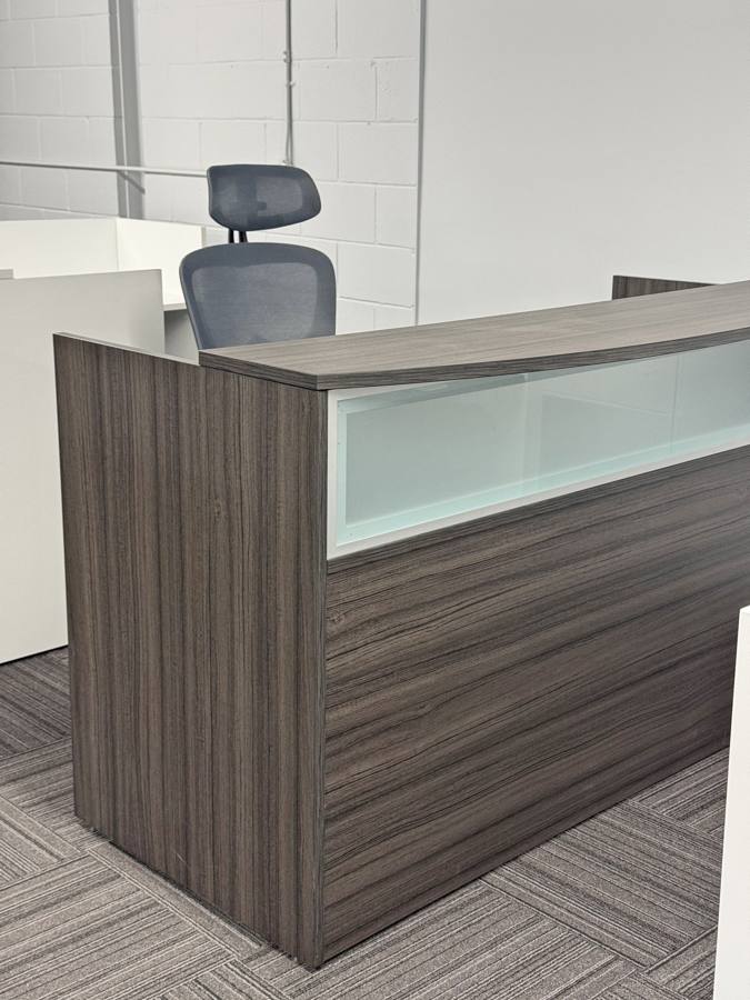 Curved reception desk with frosted glass panel in the showroom