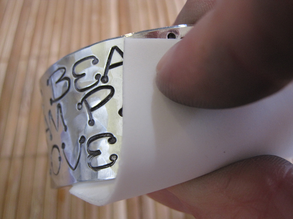 Removing excess black coloring from a hand stamped cuff bracelet