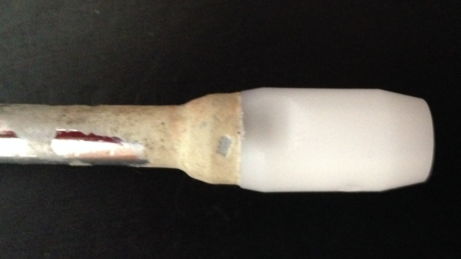 A steam wand with milk thats been baked on after several uses