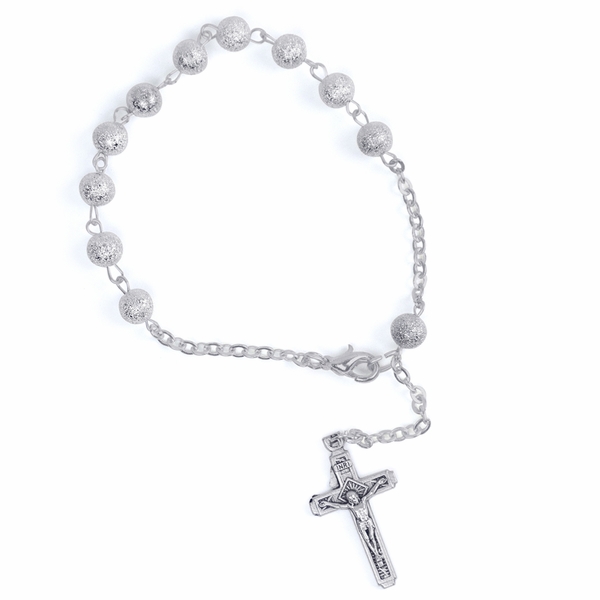 A small bracelet rosary with a few beads on the topside. The cross dangle charm is delicate silver and stone.