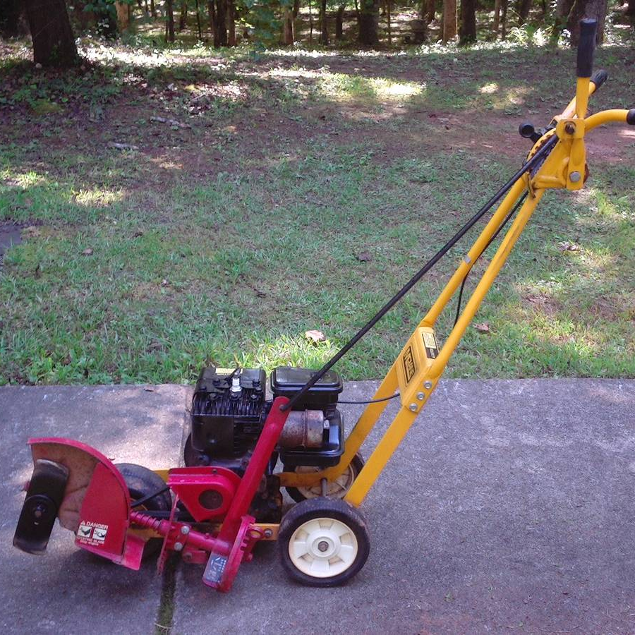 A vintage McLane edger characterized by its yellow body and handles with red blade guard