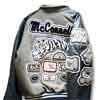 This image shows a large custom tiger chenille name patch that we created special at customchenillepatches.com. The jacket itself has a grey body and blue leather sleeves.